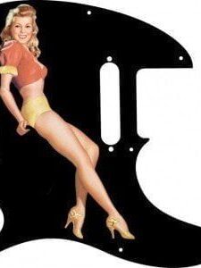 Blonde pinup girl wearing orange-red blouse with yellow panties and heals on a balck Telecaster pickguard