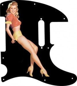 Blonde pinup girl wearing orange-red blouse with yellow panties and heals on a balck Telecaster pickguard