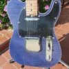body with black pickguard of blue flame maple topped tele