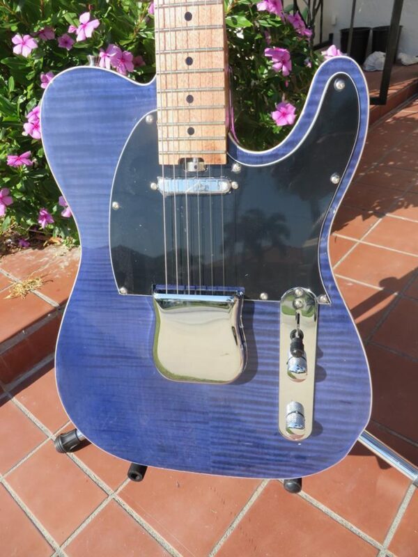 body with black pickguard of blue flame maple topped tele