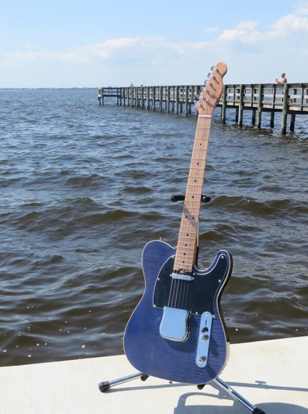 Blue Flame maple-topped tele on a stand by the water
